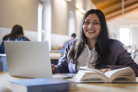 biblioteca umanistica studentessa seduta al tavolo nella biblioteca umanistica